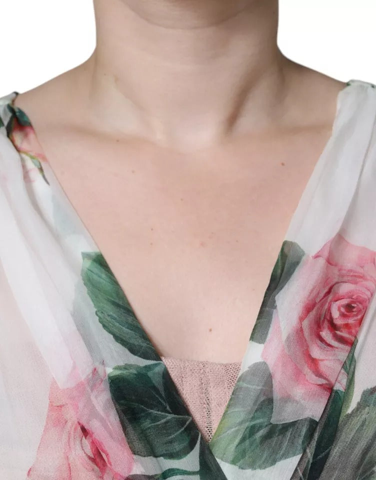A woman wearing a white silk floral print midi dress with an A-line cut