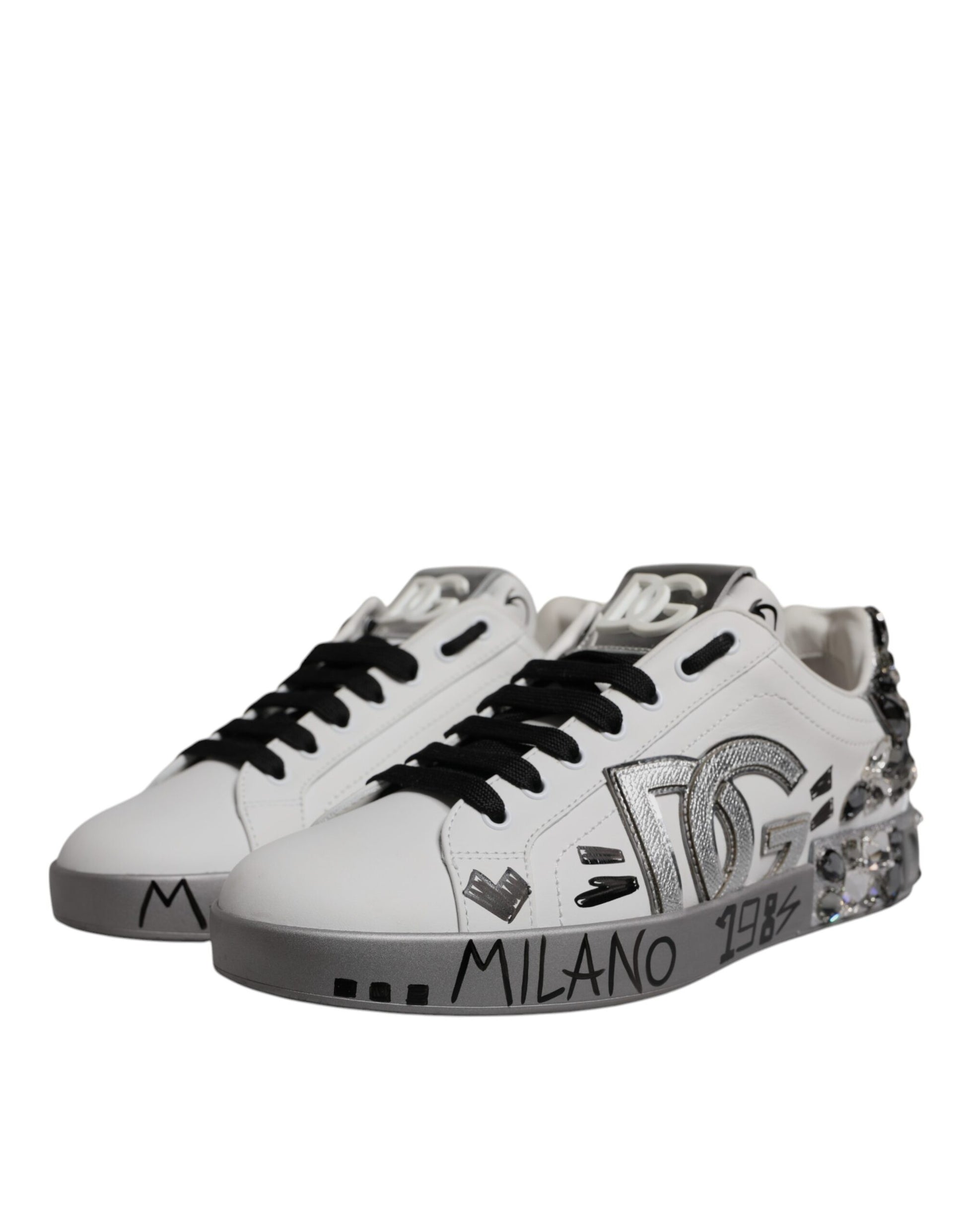 Pair of white sneakers with black laces and silver accents