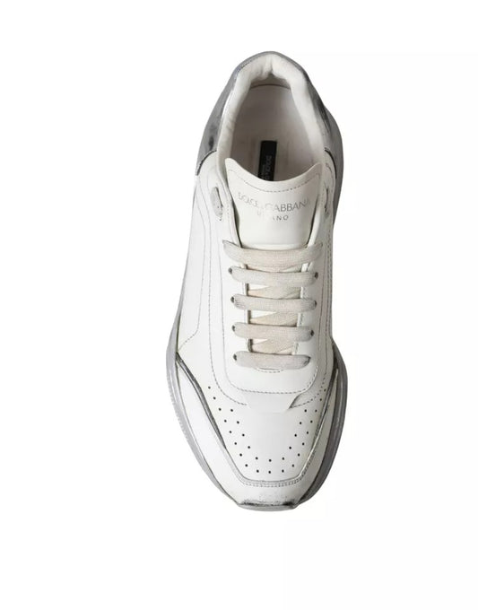 A pair of white and silver sneakers with a low top, featuring the brand name "Dolce & Gabbana" on the side