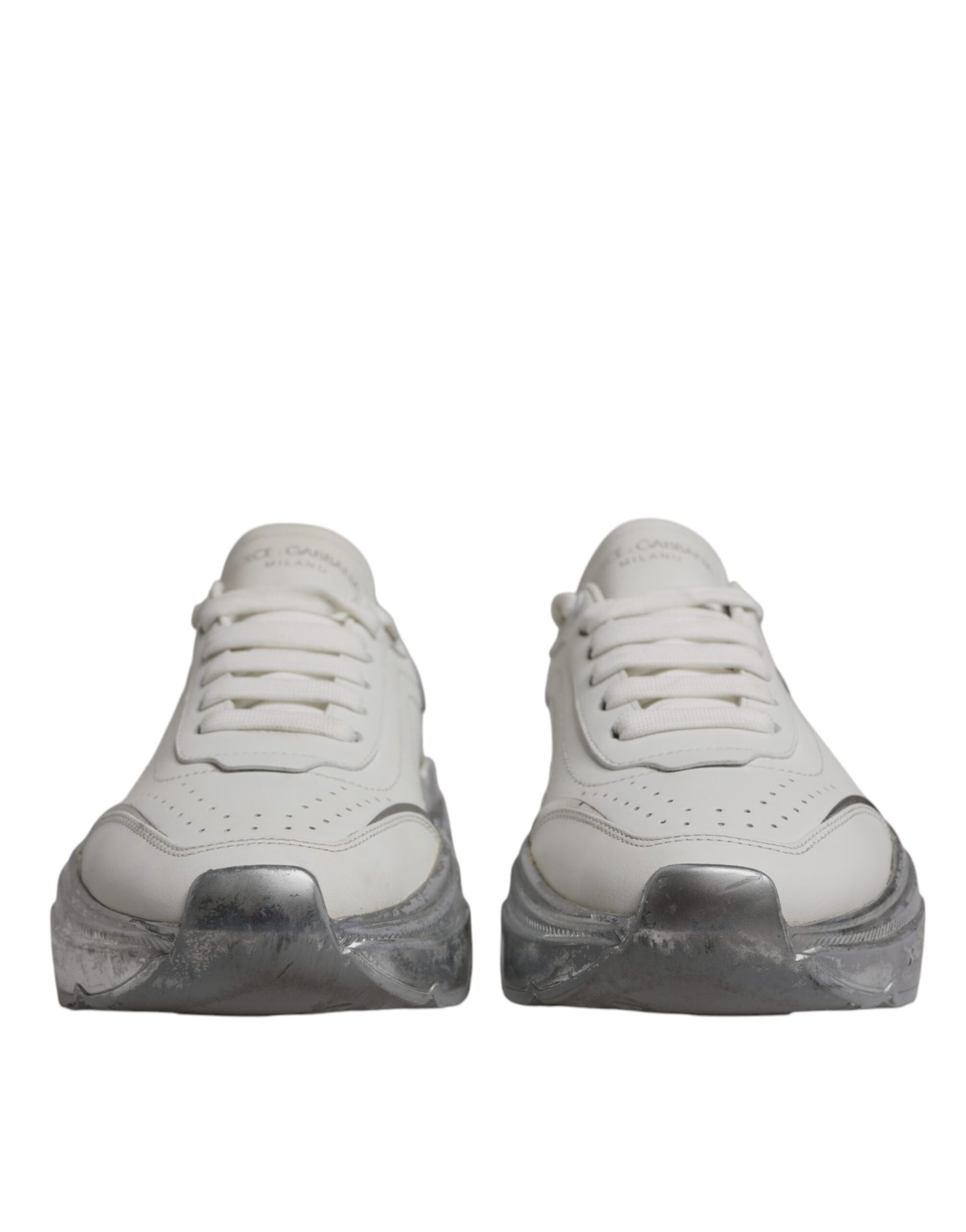 Pair of white sneakers with silver accents, featuring a low top design and a chunky sole