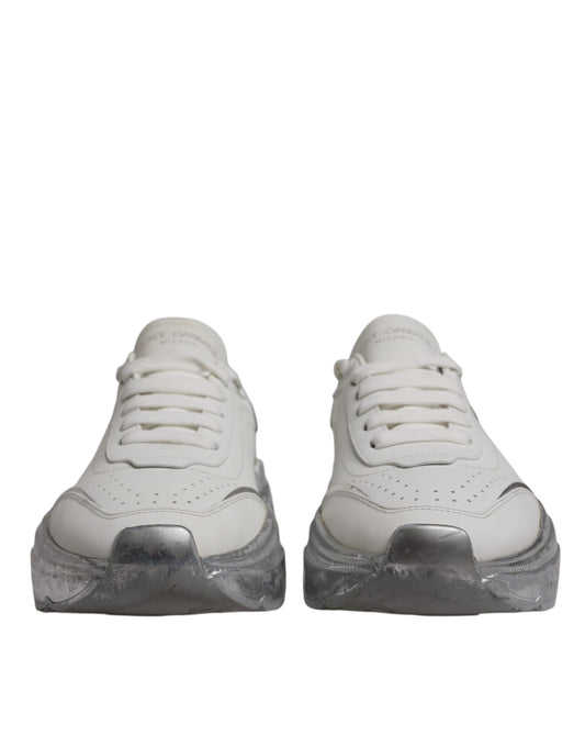 Pair of white sneakers with silver accents, featuring a low top design and a chunky sole