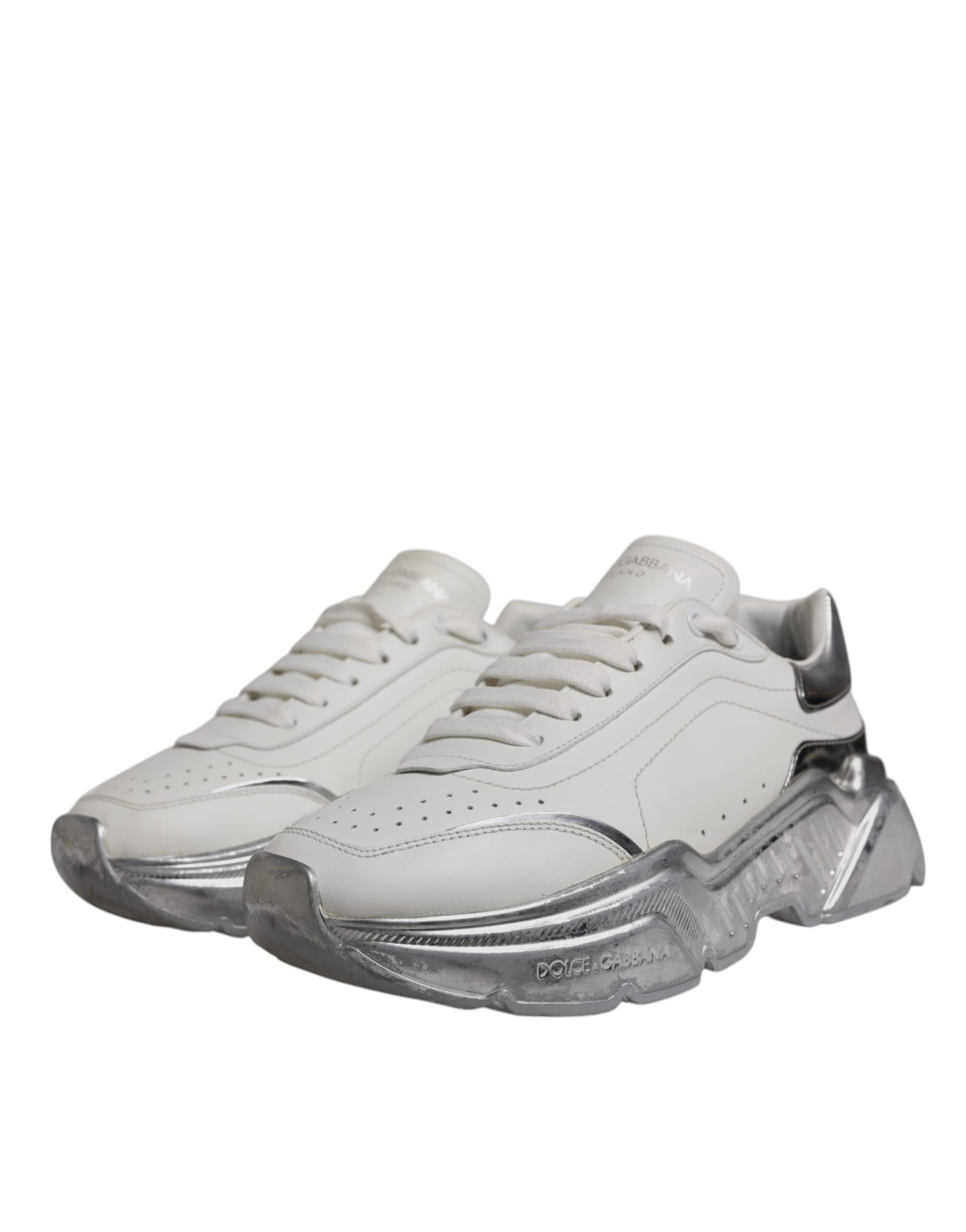 A pair of white and silver sneakers with a low top, featuring the brand name "Dolce & Gabbana" on the side