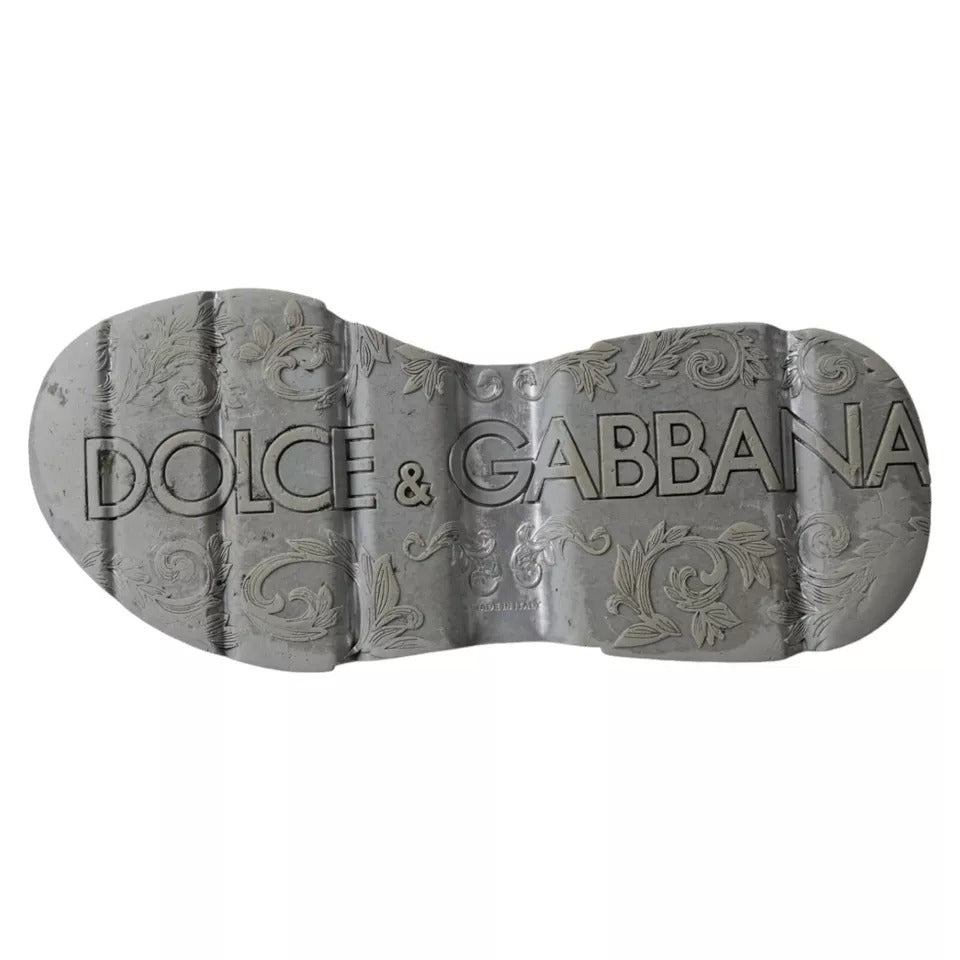A pair of silver and white sneakers with a low top, featuring the brand name "Dolce & Gabbana" on the side