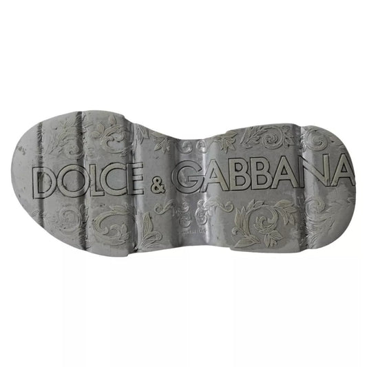 A pair of silver and white sneakers with a low top, featuring the brand name "Dolce & Gabbana" on the side