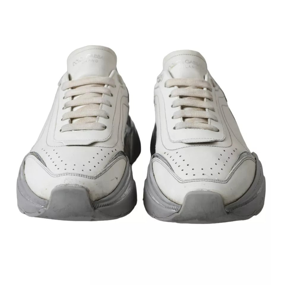 Pair of white sneakers with silver accents, featuring a low top and a logo on the side