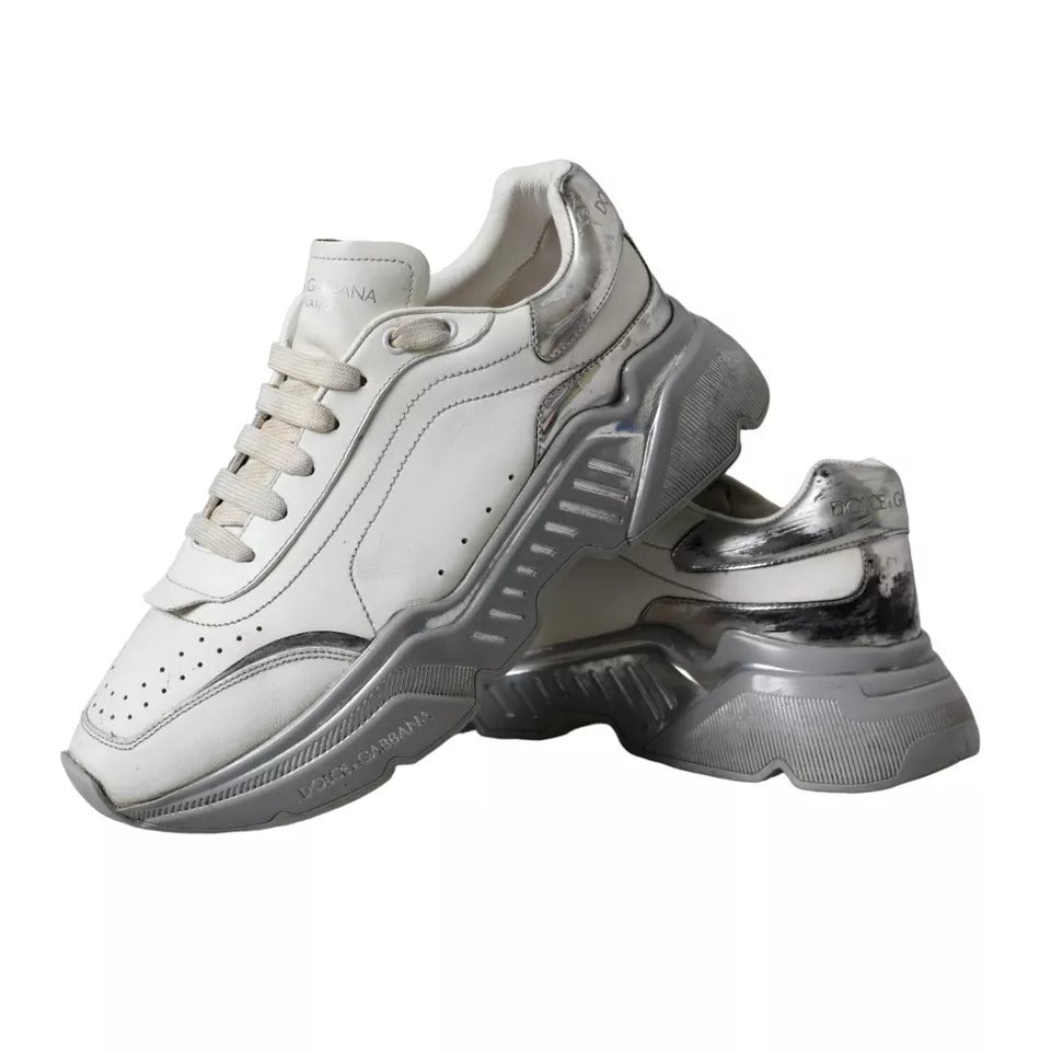 A pair of white and silver sneakers with a low top, featuring the brand name "Dolce & Gabbana" on the side