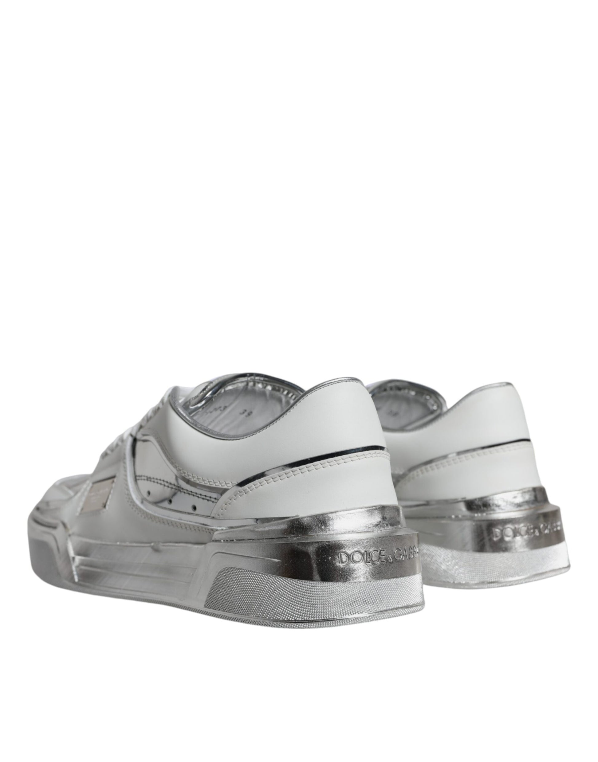 A pair of white silver leather low top sneakers with a shiny finish