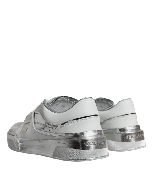 A pair of white silver leather low top sneakers with a shiny finish