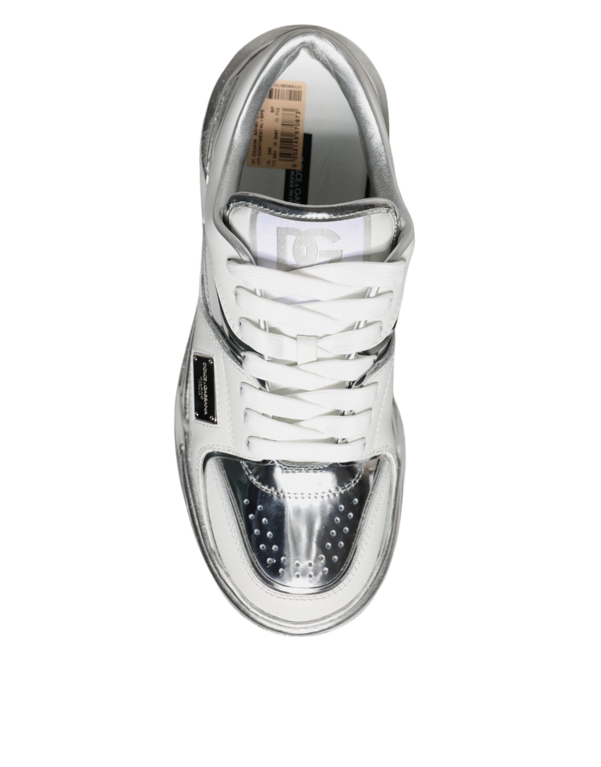 A pair of white silver leather low top sneakers with a black logo on the side