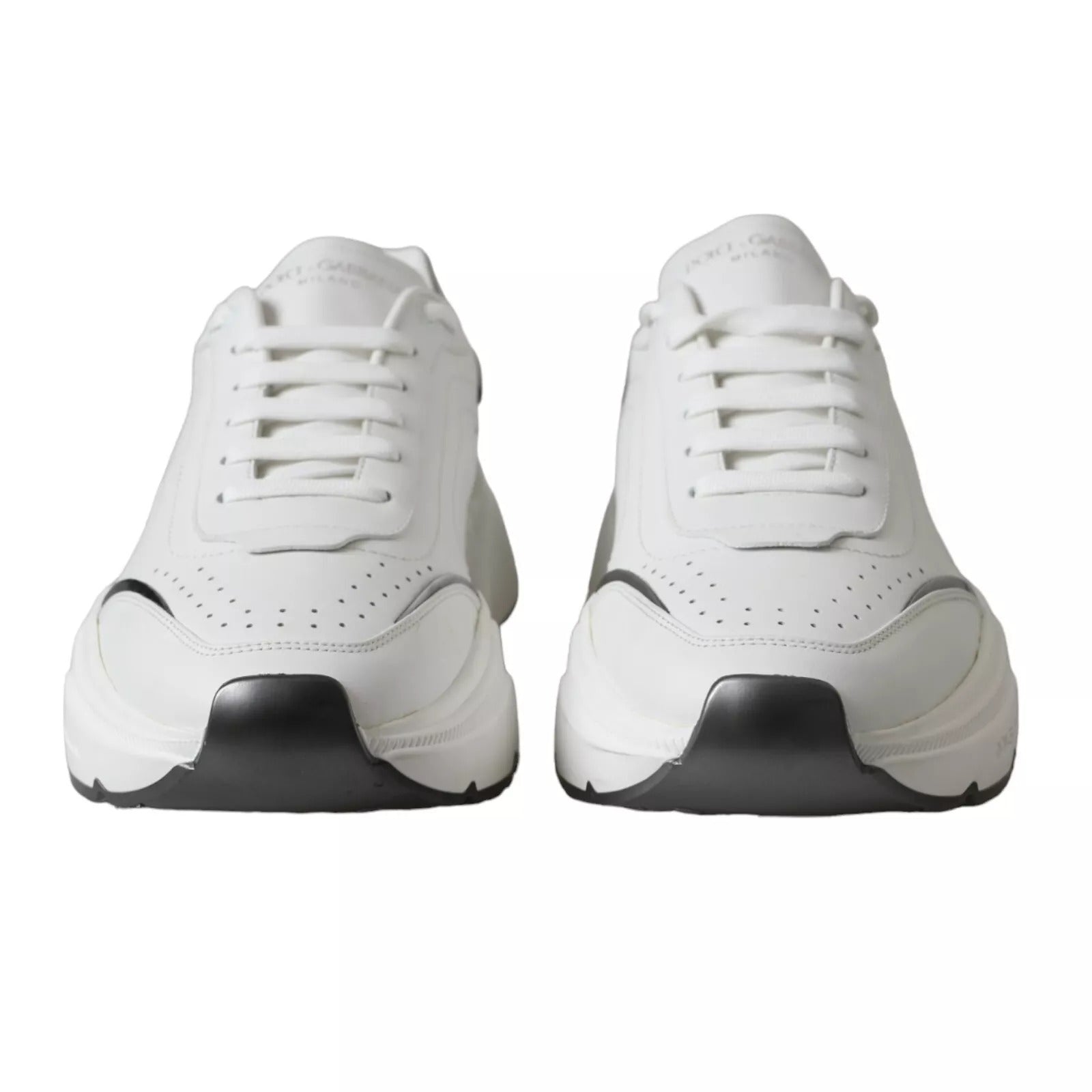 Pair of white leather sneakers with silver accents, featuring a low-top design and black soles