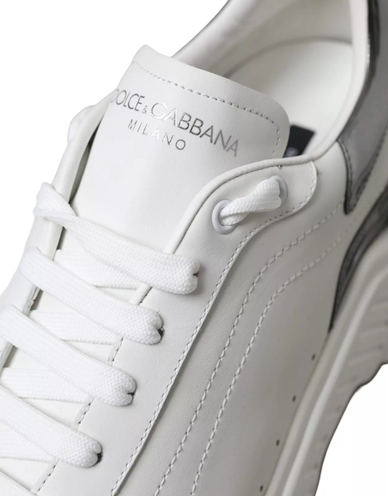 White leather sneakers with silver accents, featuring the Dolce & Gabbana logo