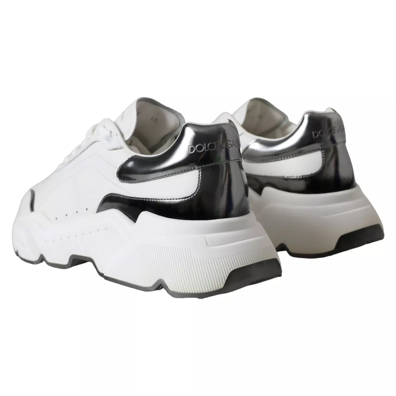 Pair of white and silver leather sneakers with black laces, featuring a low-top design