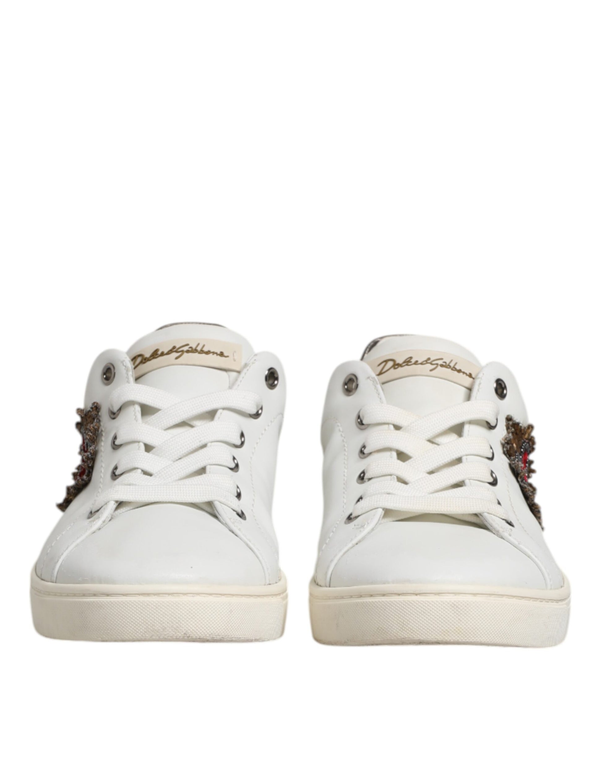 Pair of white sneakers with silver accents, featuring a sacred heart design on the side