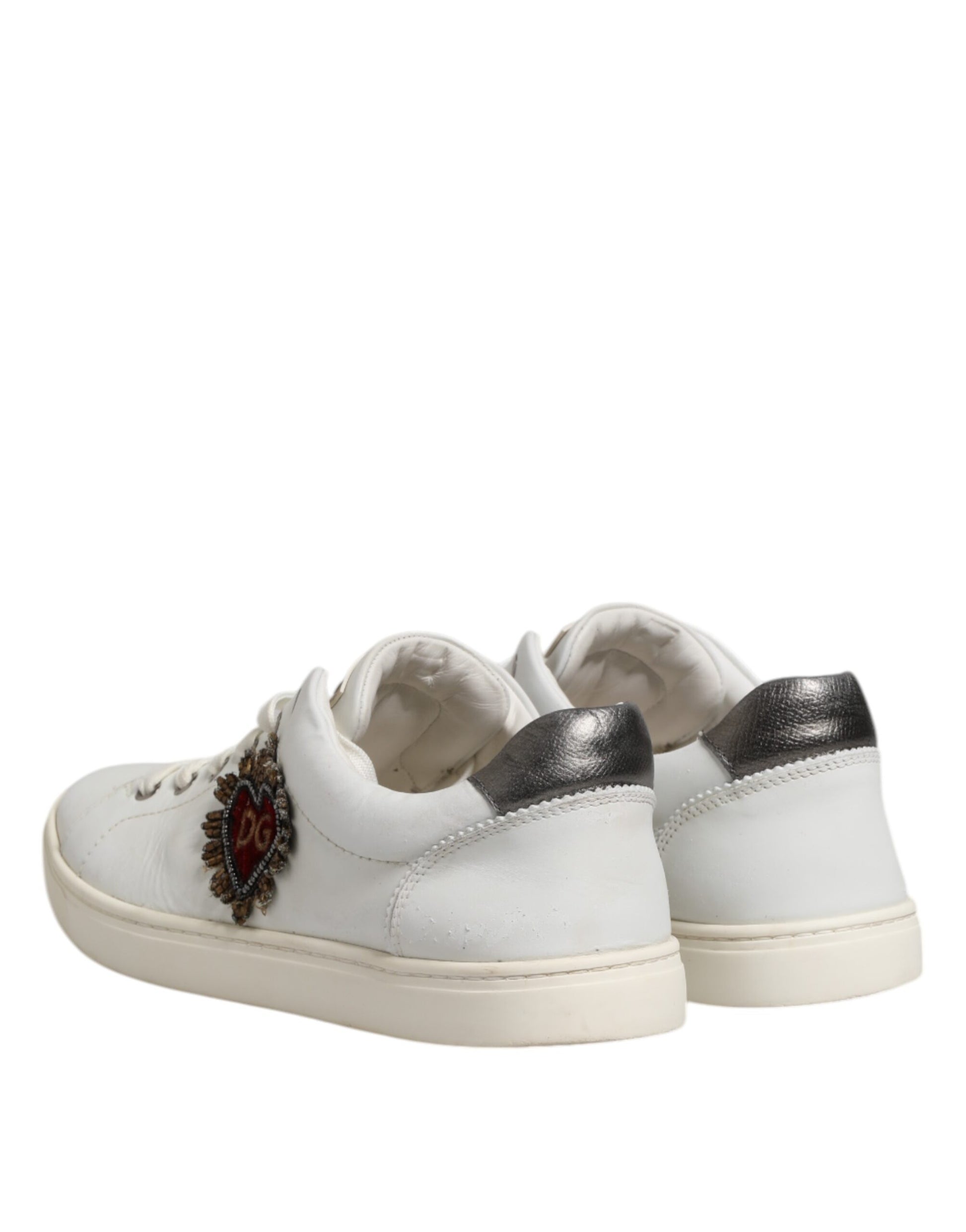 White sneakers with silver accents, featuring a sacred heart design on the side