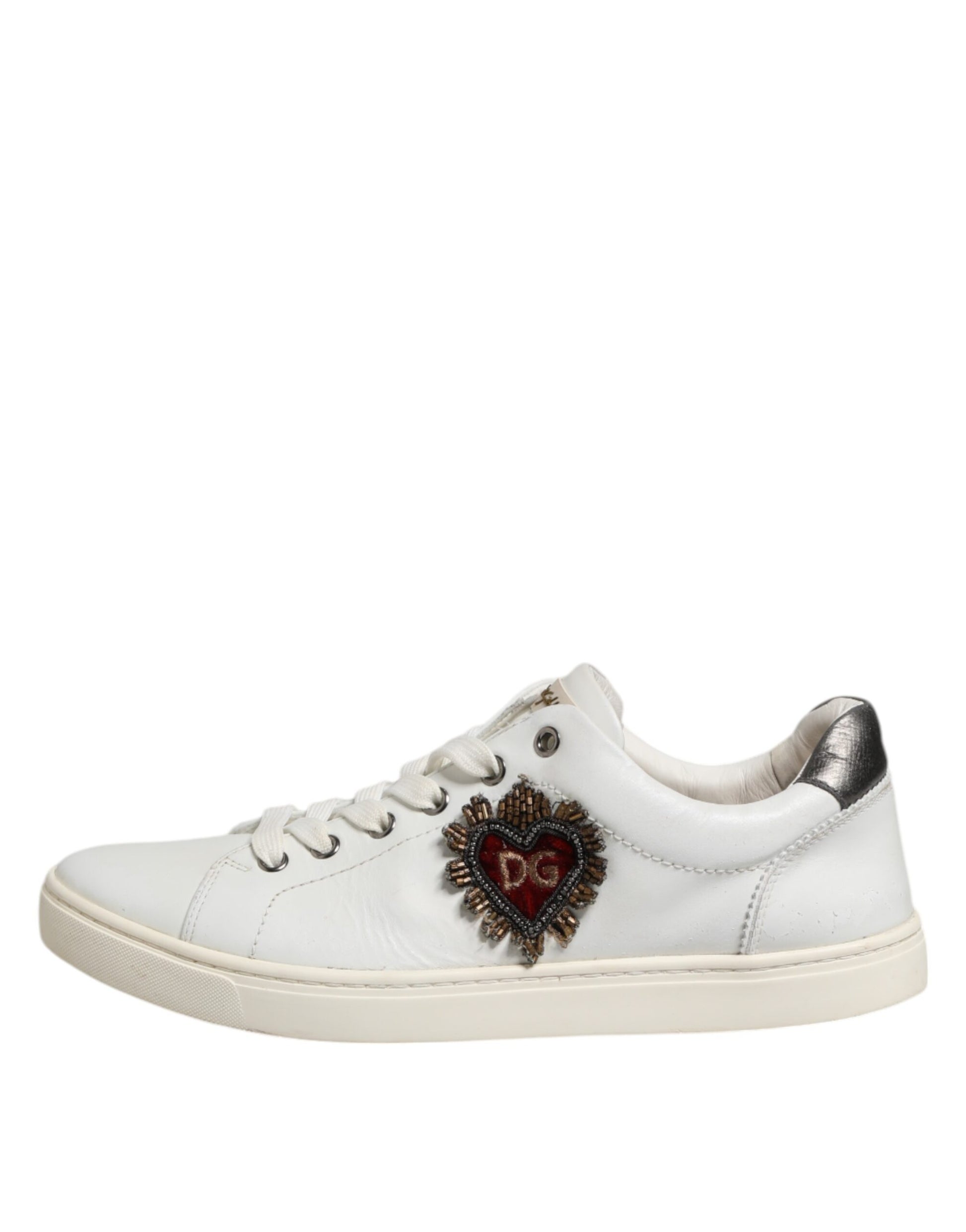 A pair of white sneakers with a silver sacred heart design on the side