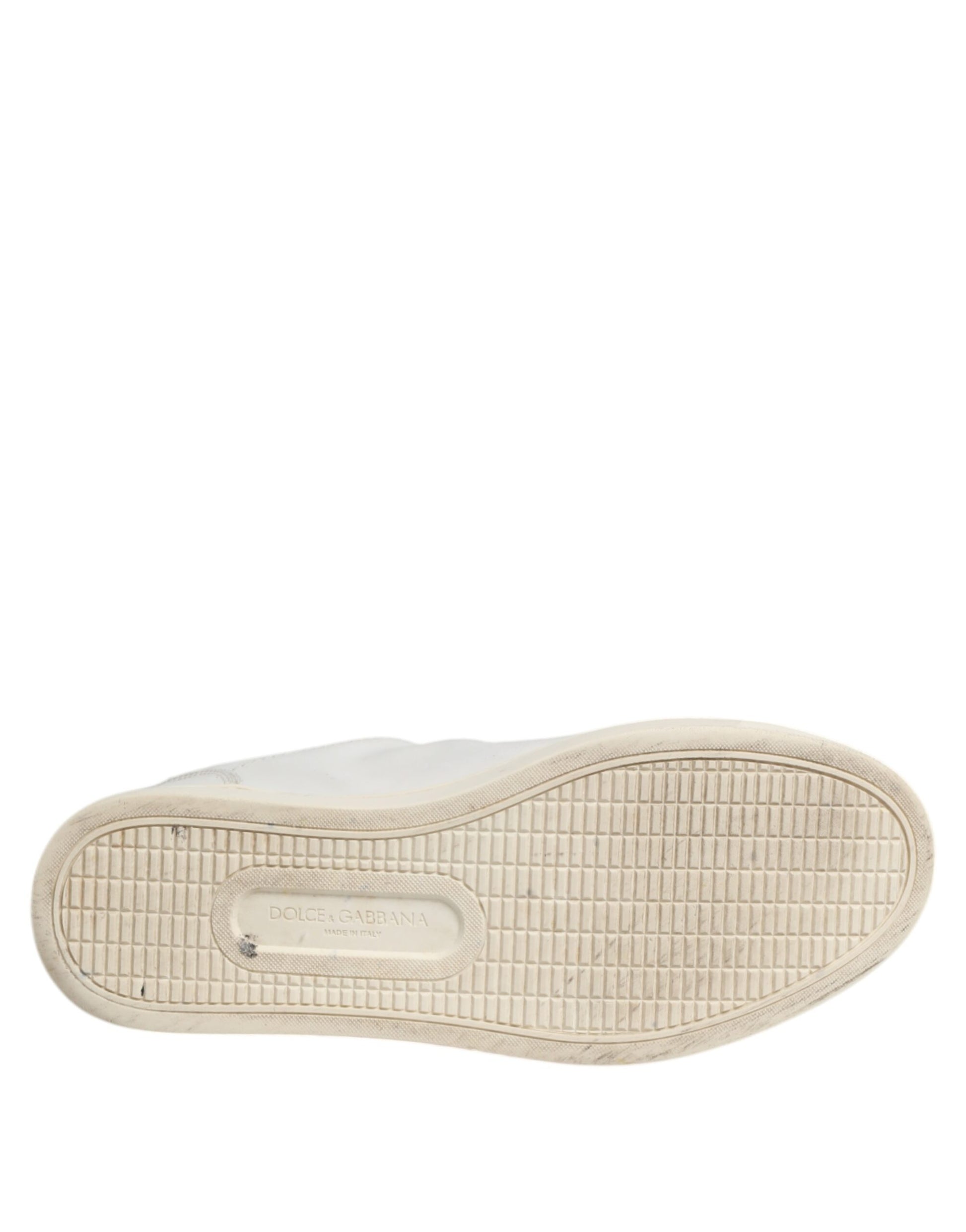 A single white sneaker with a silver heart on the side, featuring a textured sole and a lace-up front