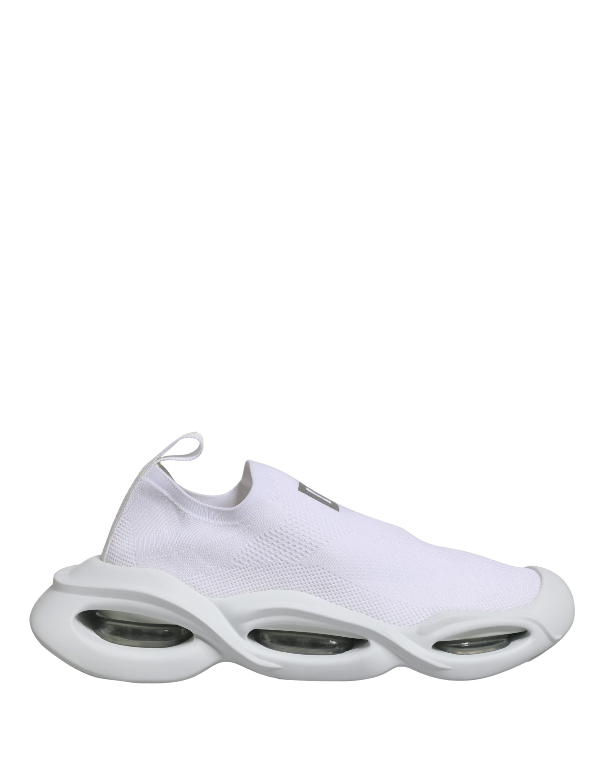 A pair of white slip-on shoes with a wave design on the sole, featuring a low top and a textured fabric upper
