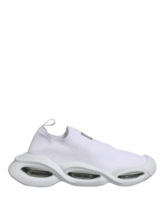 A pair of white slip-on shoes with a wave design on the sole, featuring a low top and a textured fabric upper