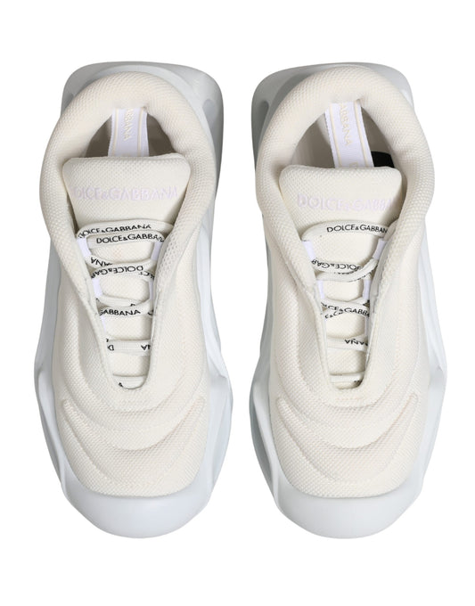 Pair of white slip-on shoes with laces, featuring a low top and a wave design on the side