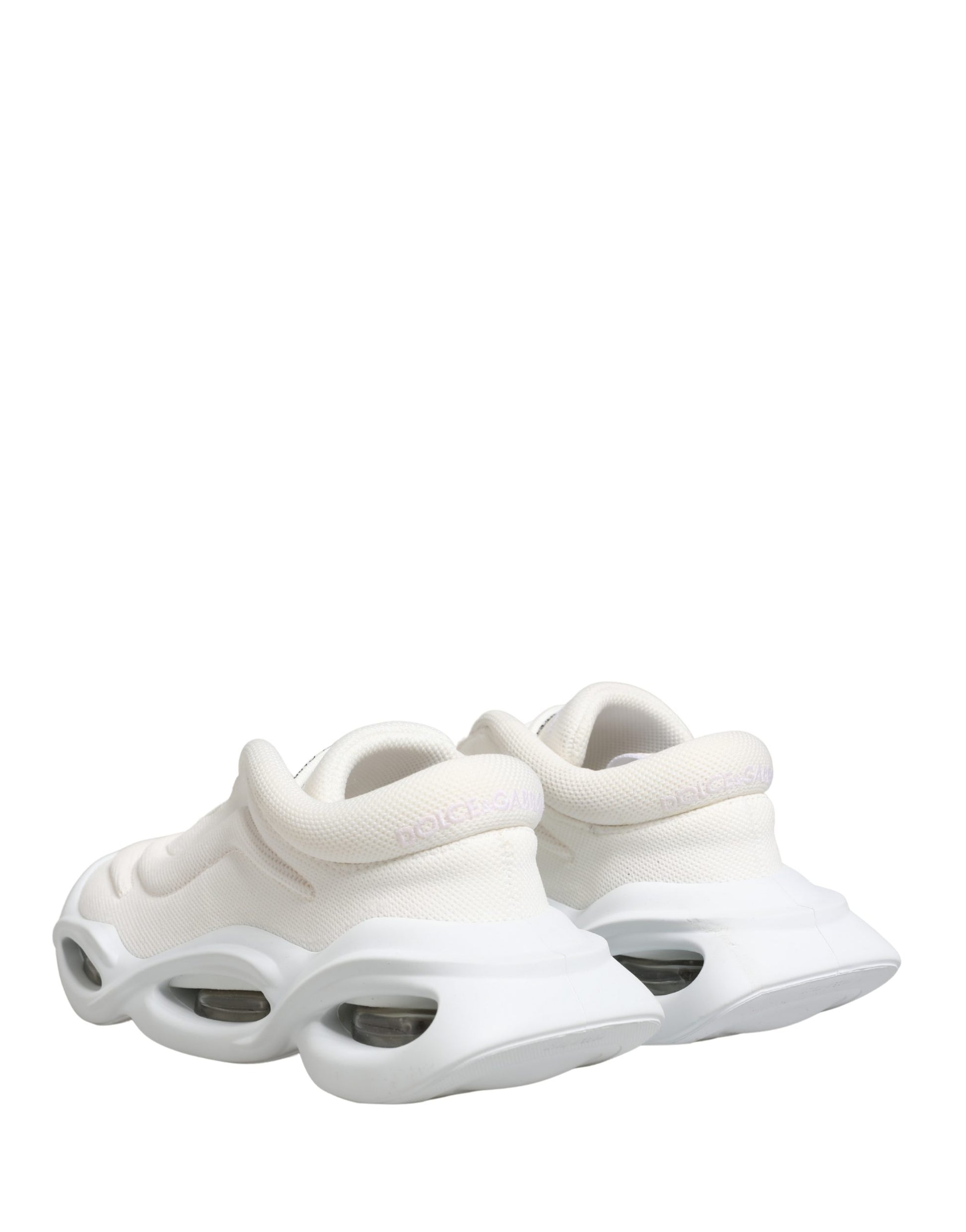 Pair of white slip-on shoes with pink accents, featuring a low top design