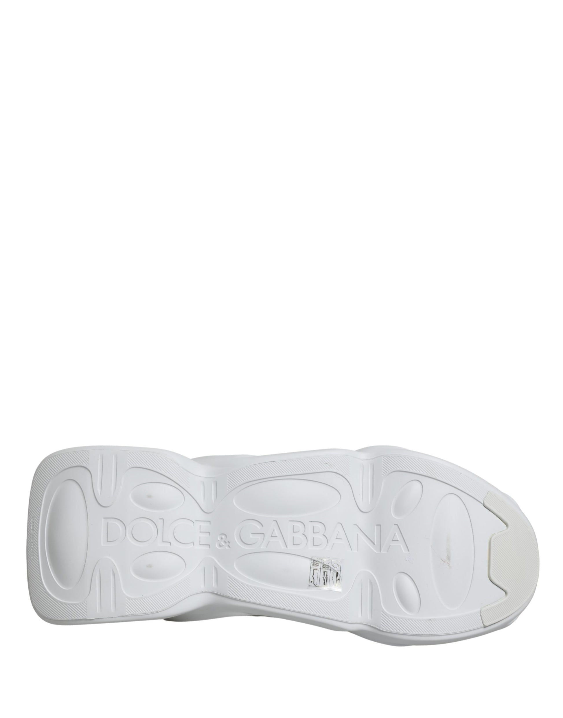 A pair of white slip-on shoes with a wave design on the sole, featuring the Dolce & Gabbana logo