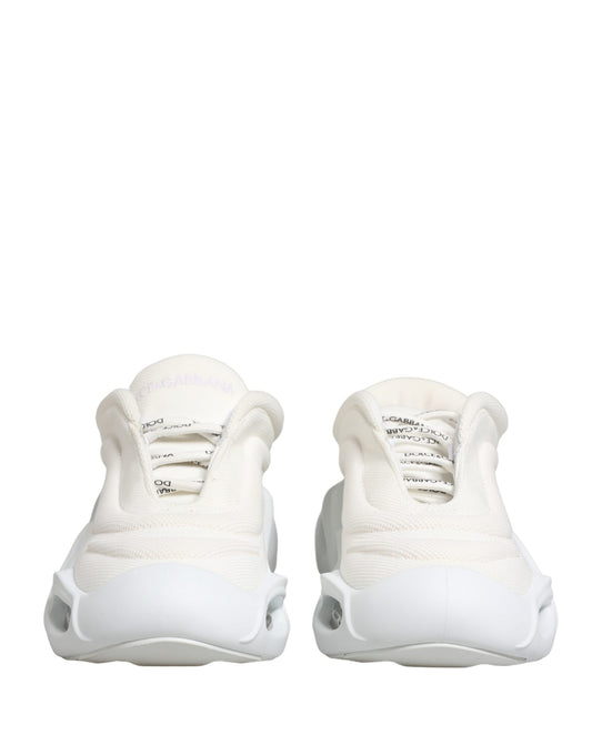 Pair of white slip-on shoes with laces and logo on side
