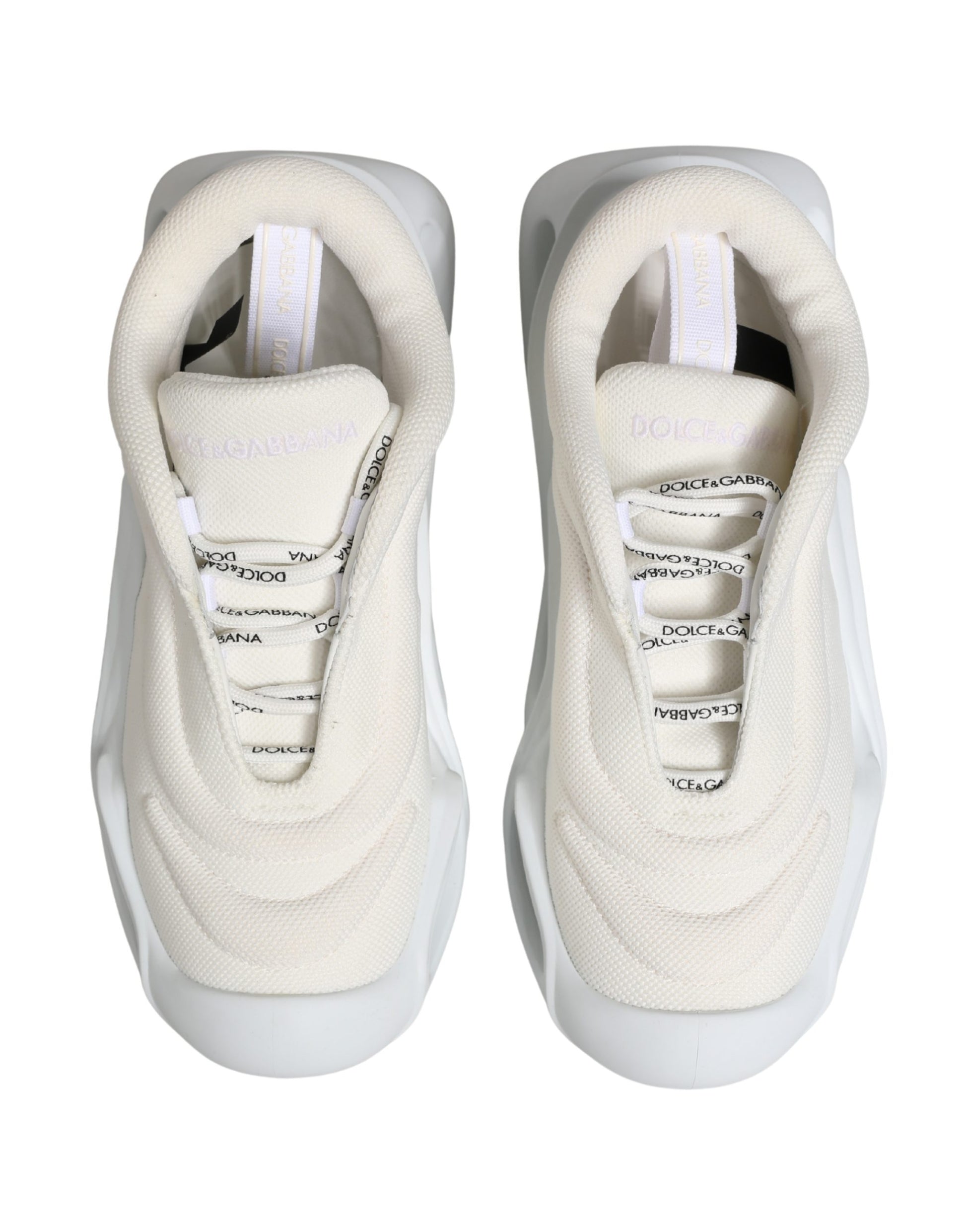 Pair of white slip-on shoes with black laces and logo on side