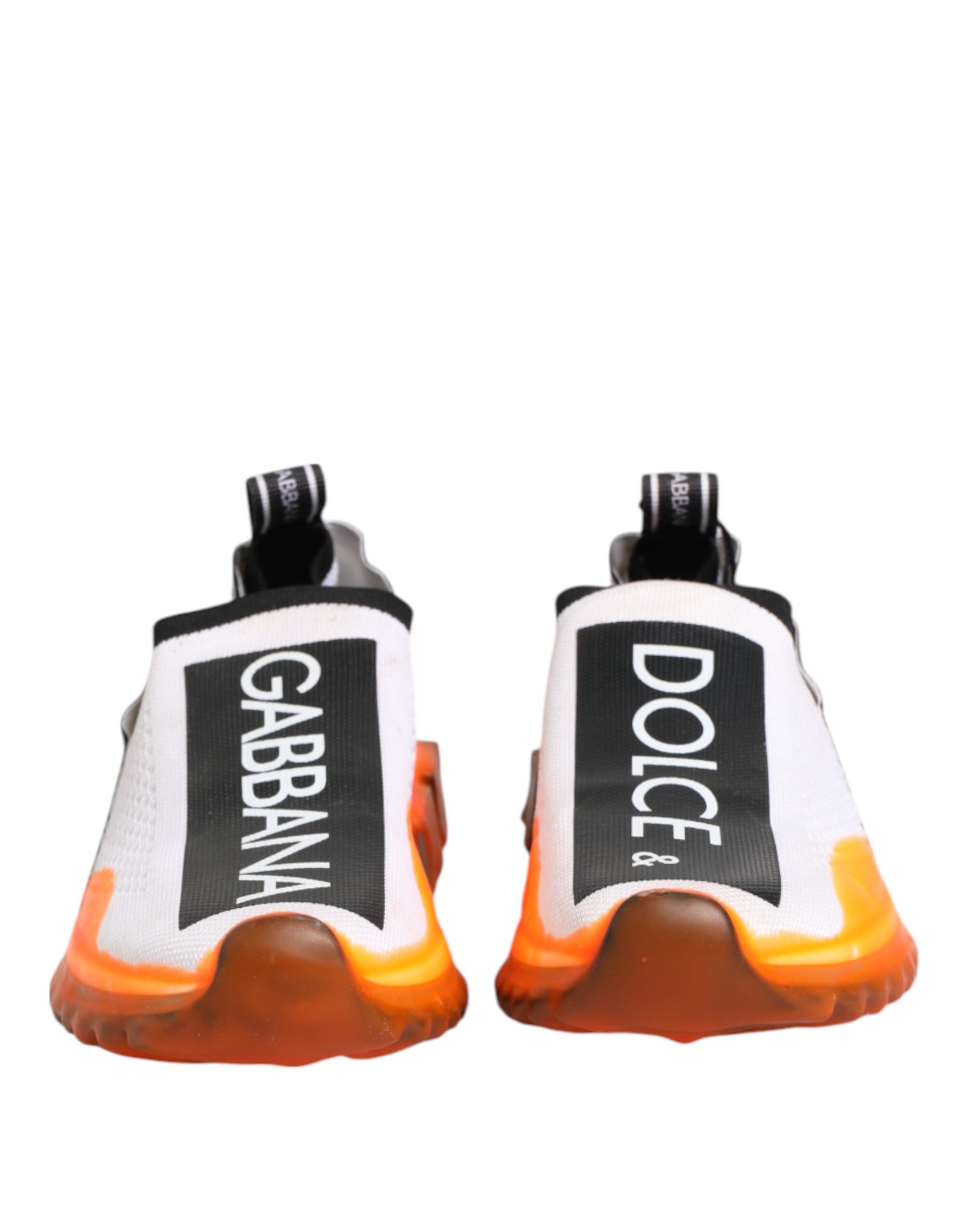 Pair of white slip-on shoes with black and orange accents, featuring the Dolce & Gabbana logo