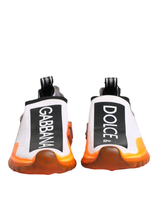 Pair of white slip-on shoes with black and orange accents, featuring the Dolce & Gabbana logo