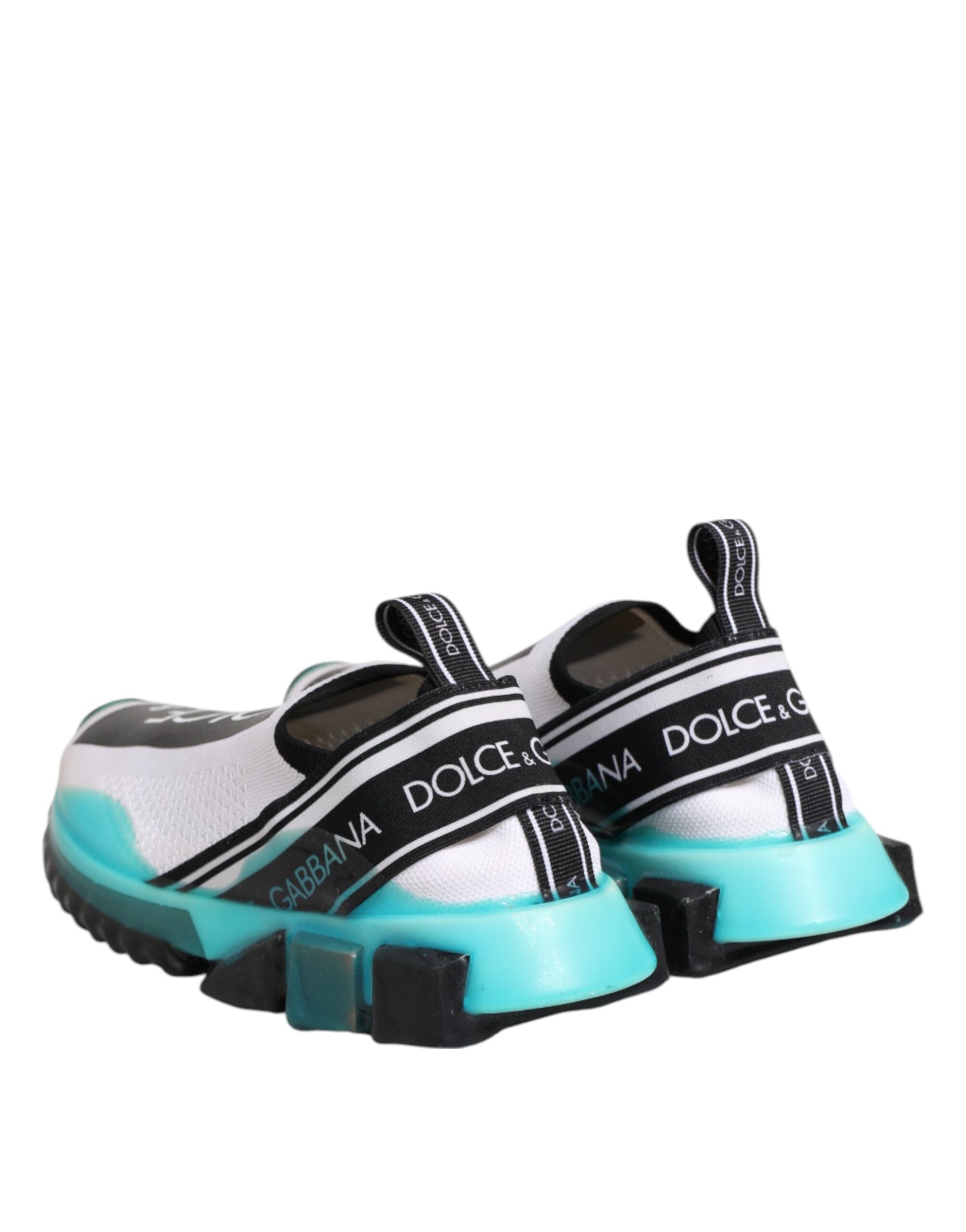A pair of white slip-on shoes with a black and green design, featuring the Dolce & Gabbana logo