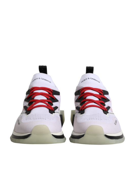 Pair of white sneakers with red laces and black accents, featuring a stretchy knit upper
