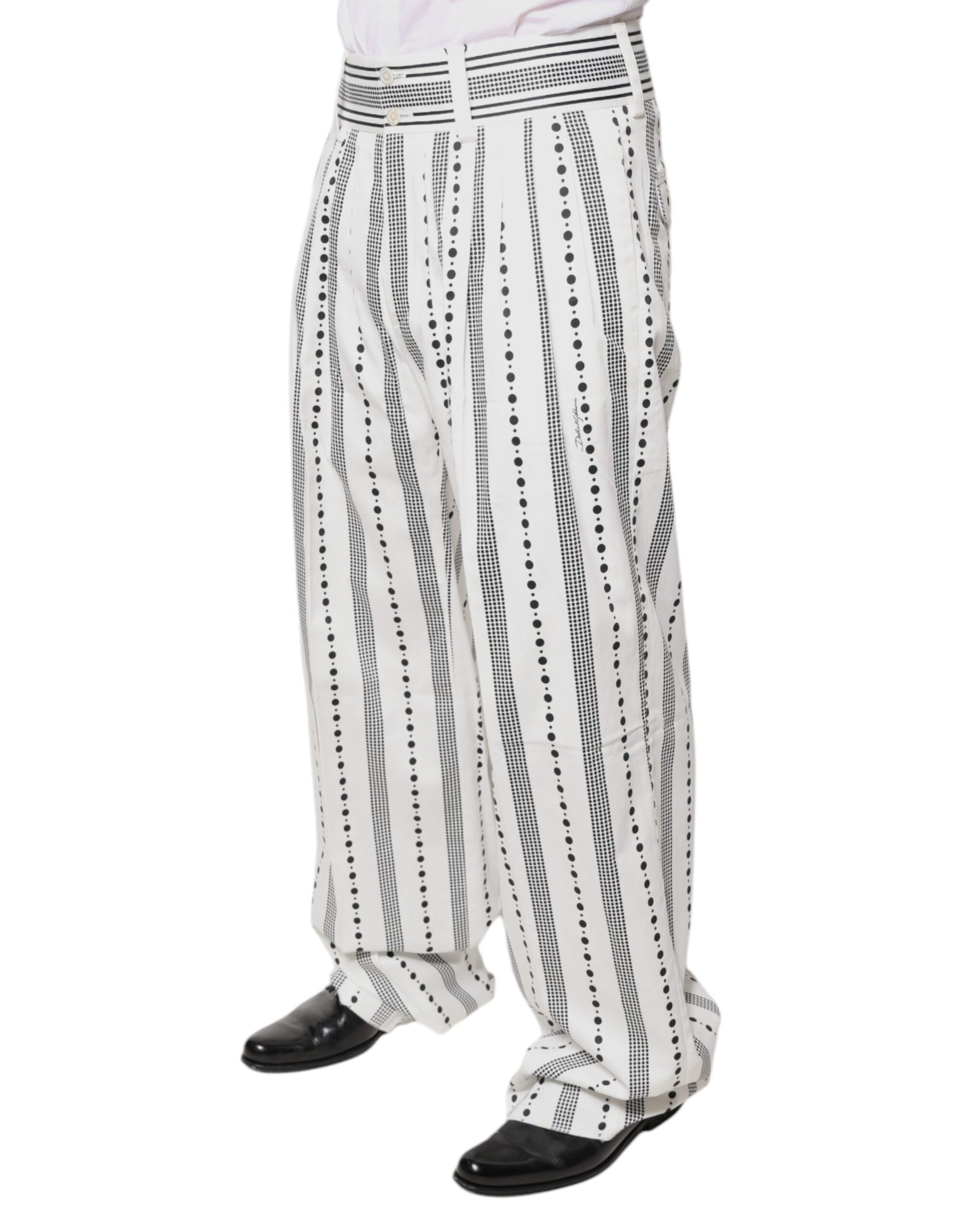 Man wearing white shirt, black pants with white dots, and black shoes