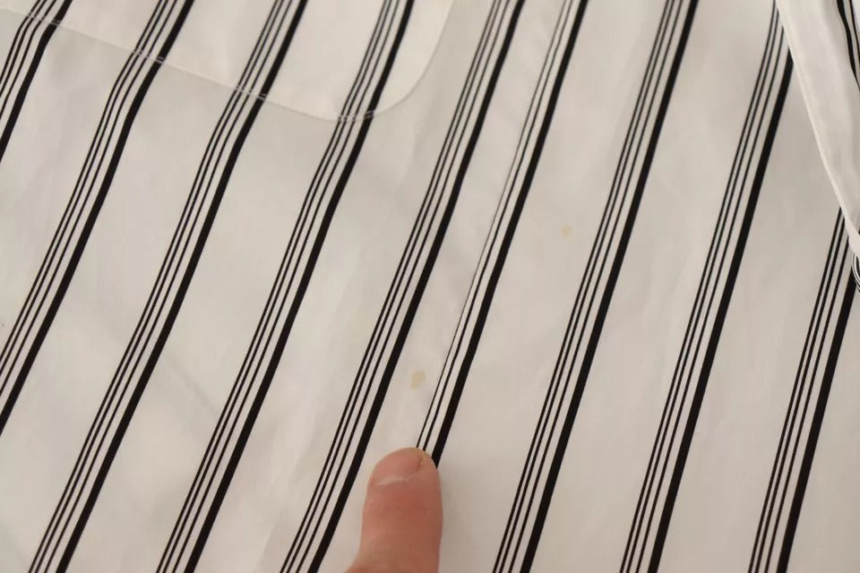 Hand pointing at black and white striped paper