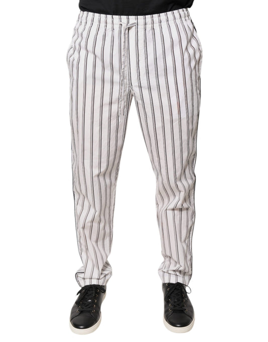 A pair of white pants with black stripes, featuring an elastic waistband and cuffs. They are designed by Dolc