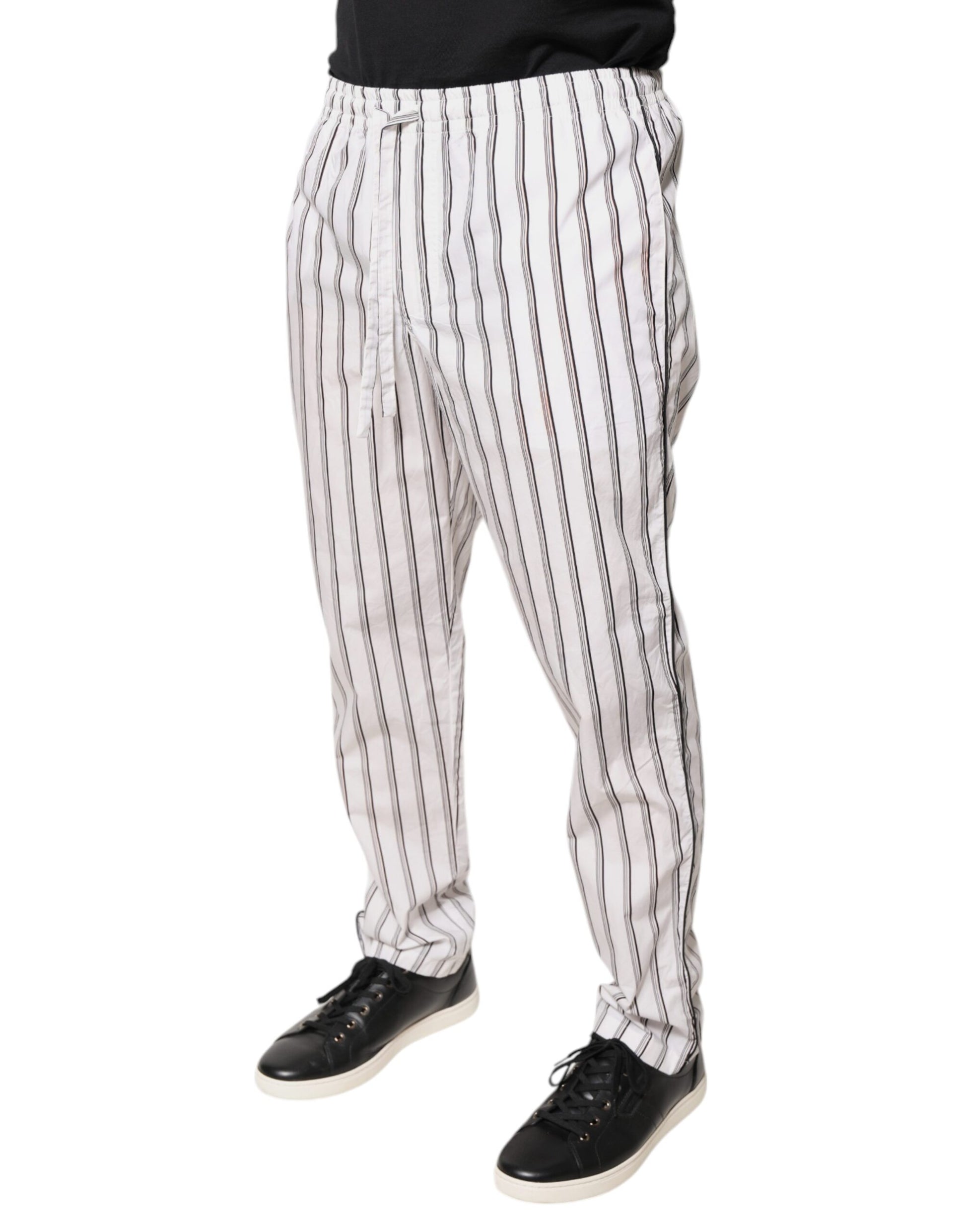 A pair of white pants with black stripes, featuring an elastic waistband and cuffs. They are designed by Dolc