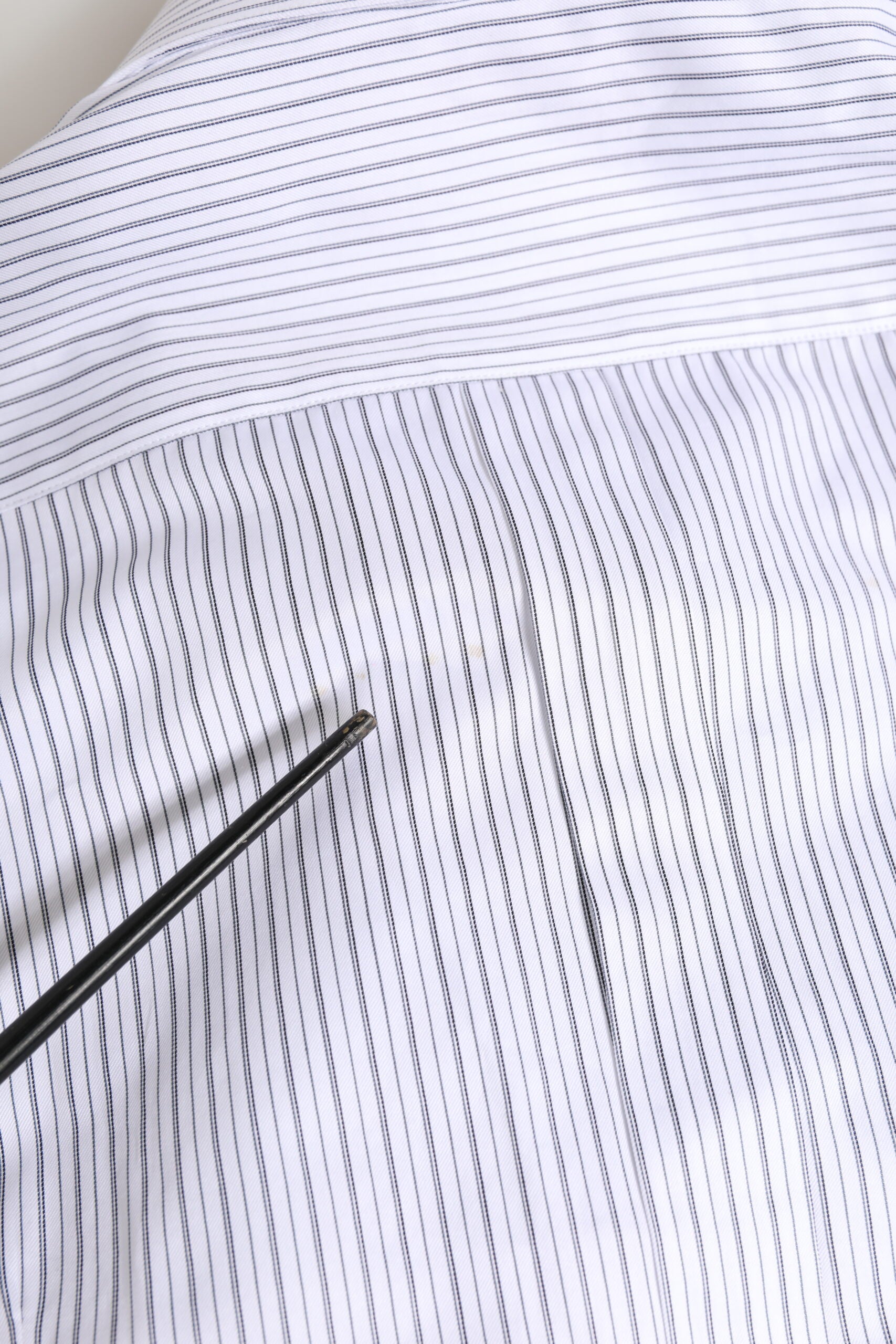 A white long sleeve dress shirt with gold stripes