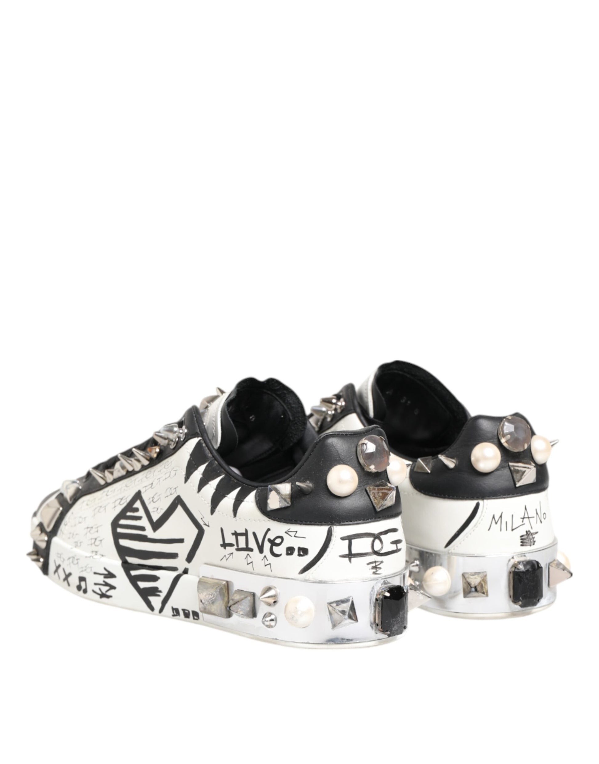 A pair of white sneakers with black studs and a printed design, featuring the words "Live Love" on the side