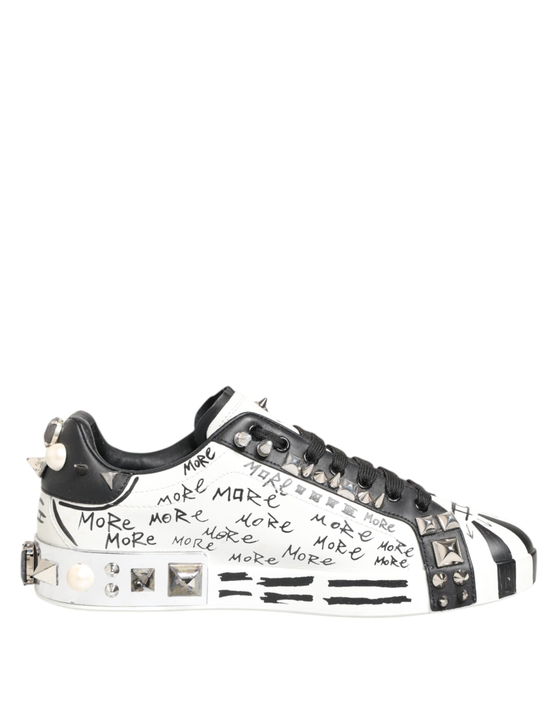 A pair of white sneakers with black studs and a printed message on the side, designed by Dolce & Gabbana