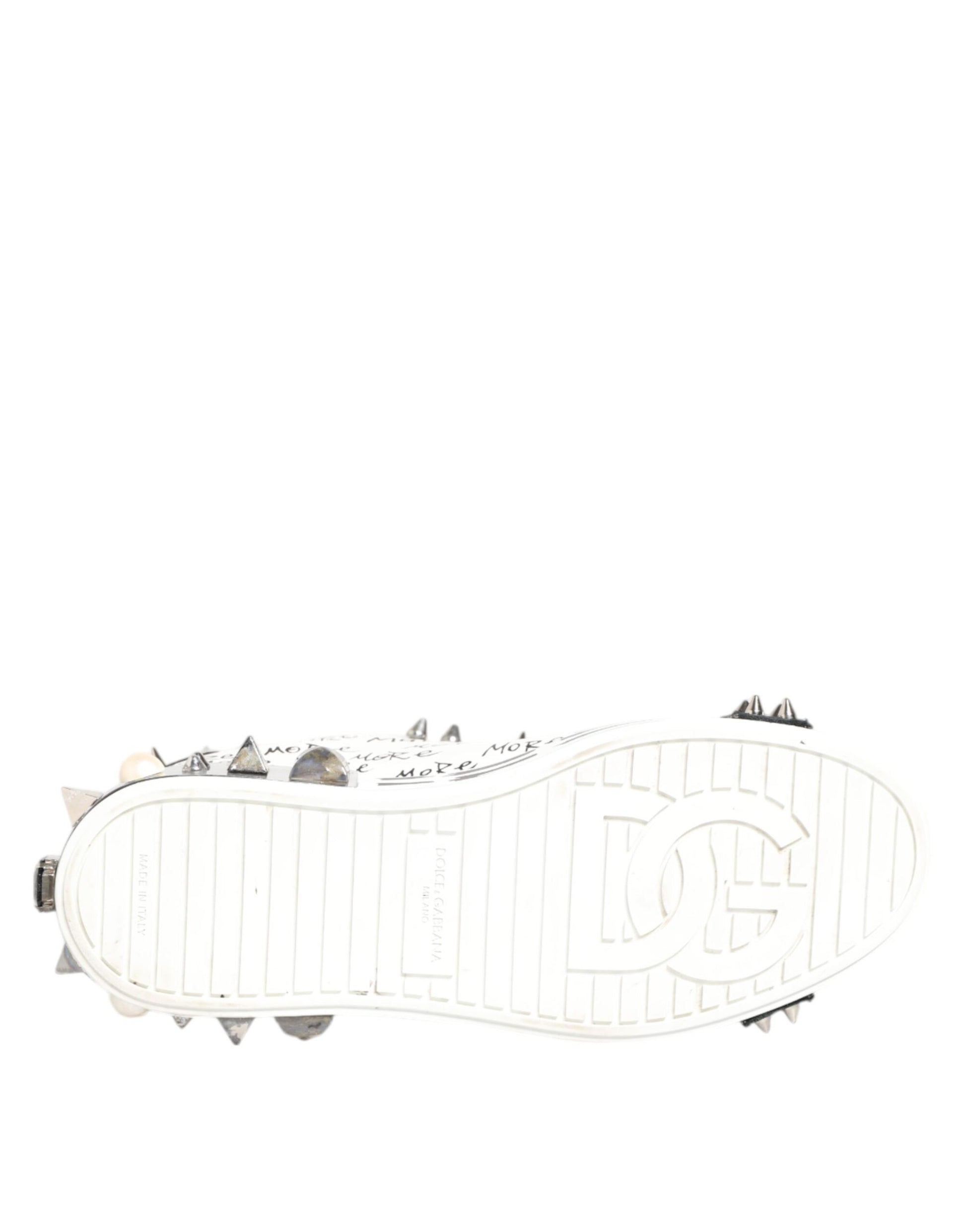 A pair of white sneakers with a printed design and studded details on the side