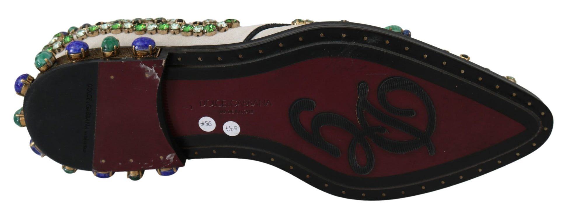 Decorative shoe with red base and gold accents, featuring a design that resembles a footprint