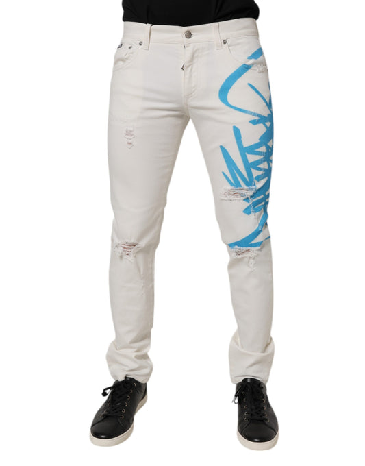Pair of distressed denim jeans with blue graffiti design on legs