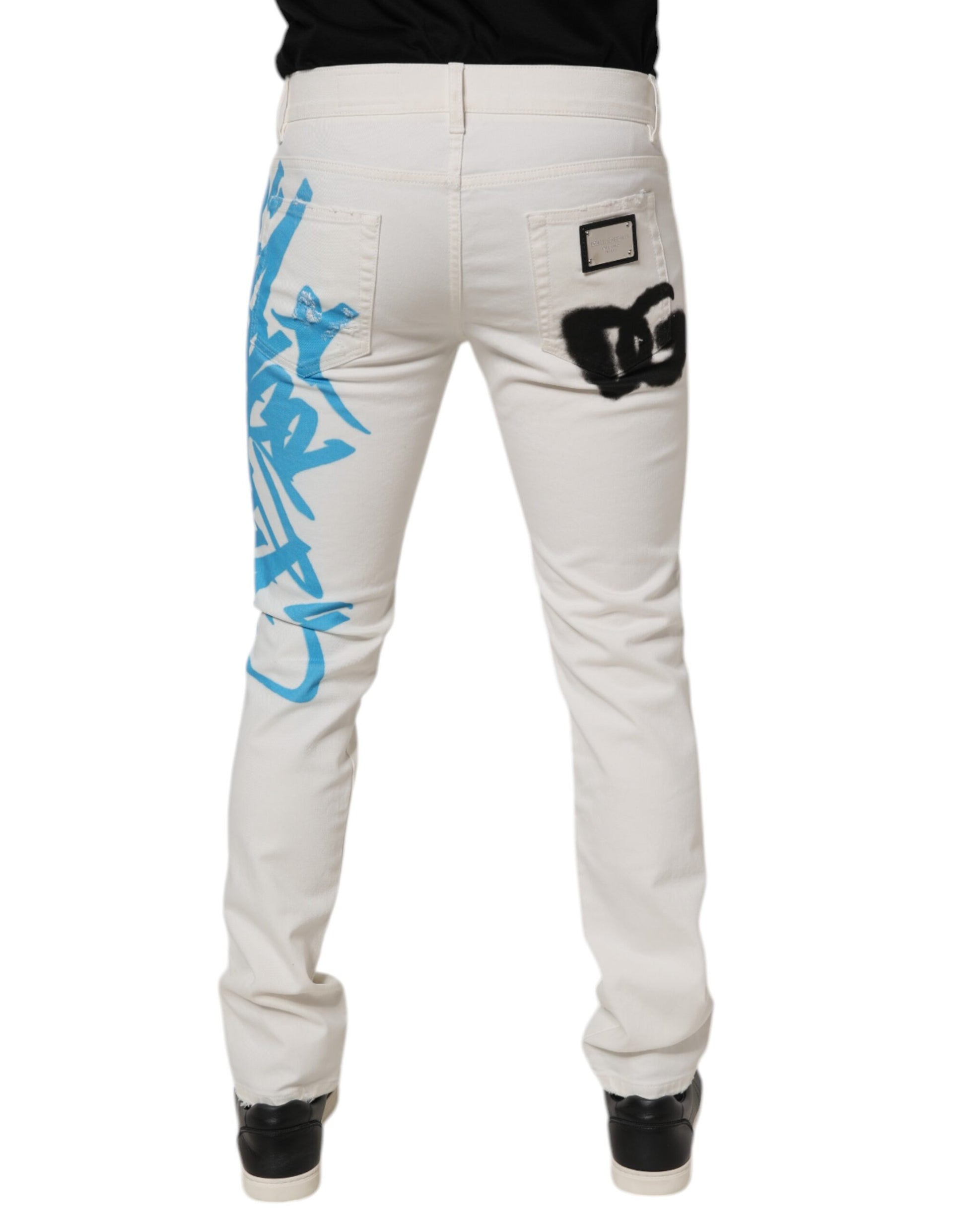 Pair of light wash denim jeans with blue graffiti on back
