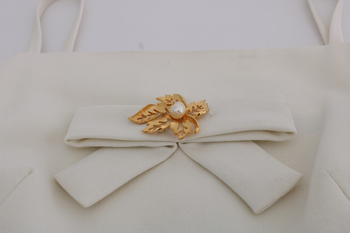 White bag with gold bow and pearl brooch