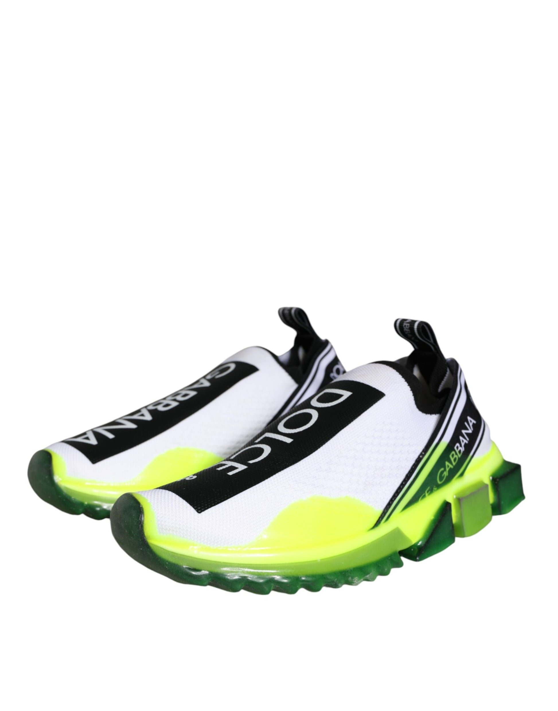 A pair of white and yellow slip-on shoes with black laces, featuring the Dolce & Gabbana logo