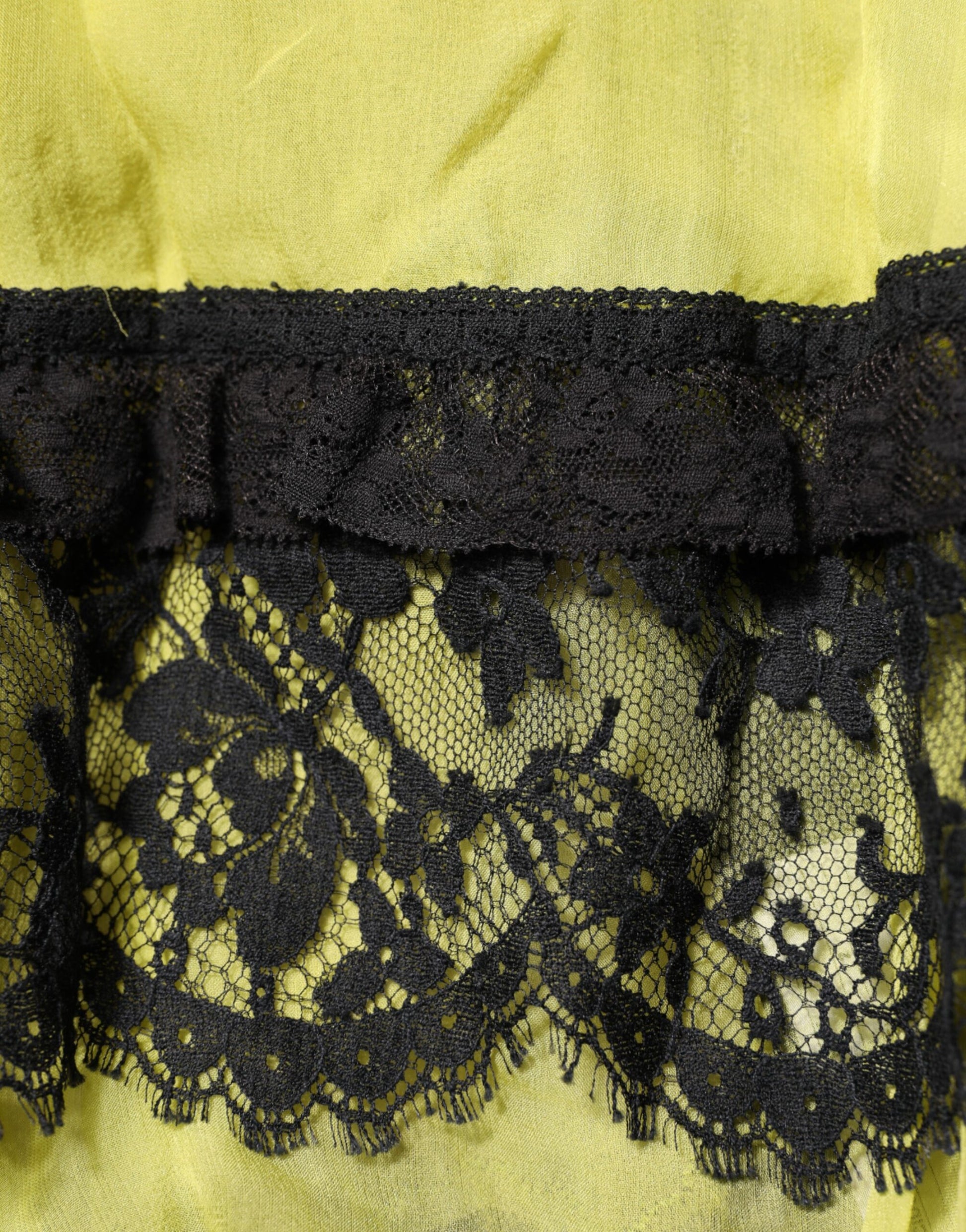 A black lace babydoll chemise with yellow trim, part of a lingerie dress