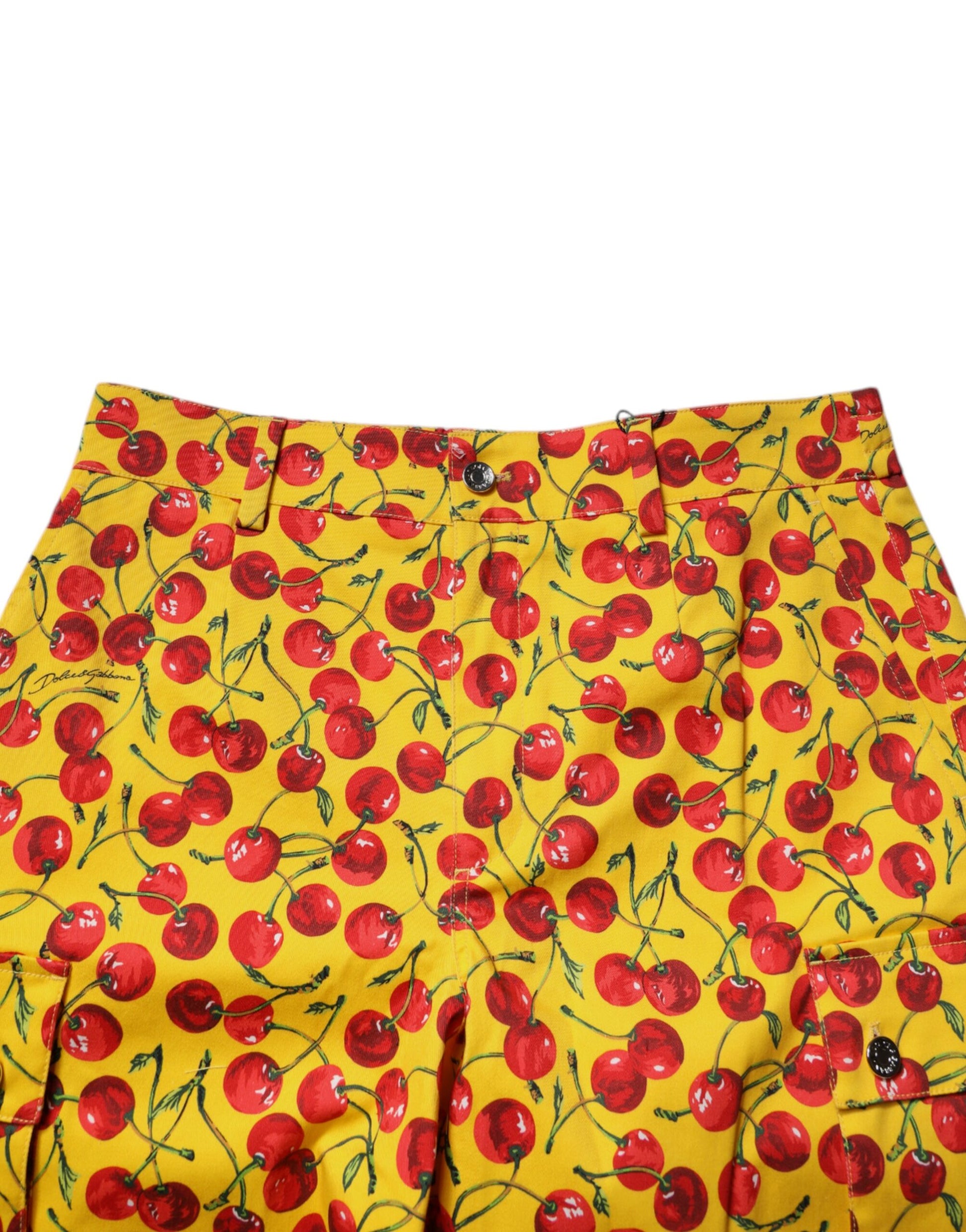 A pair of yellow shorts with a cherry print and green leaves