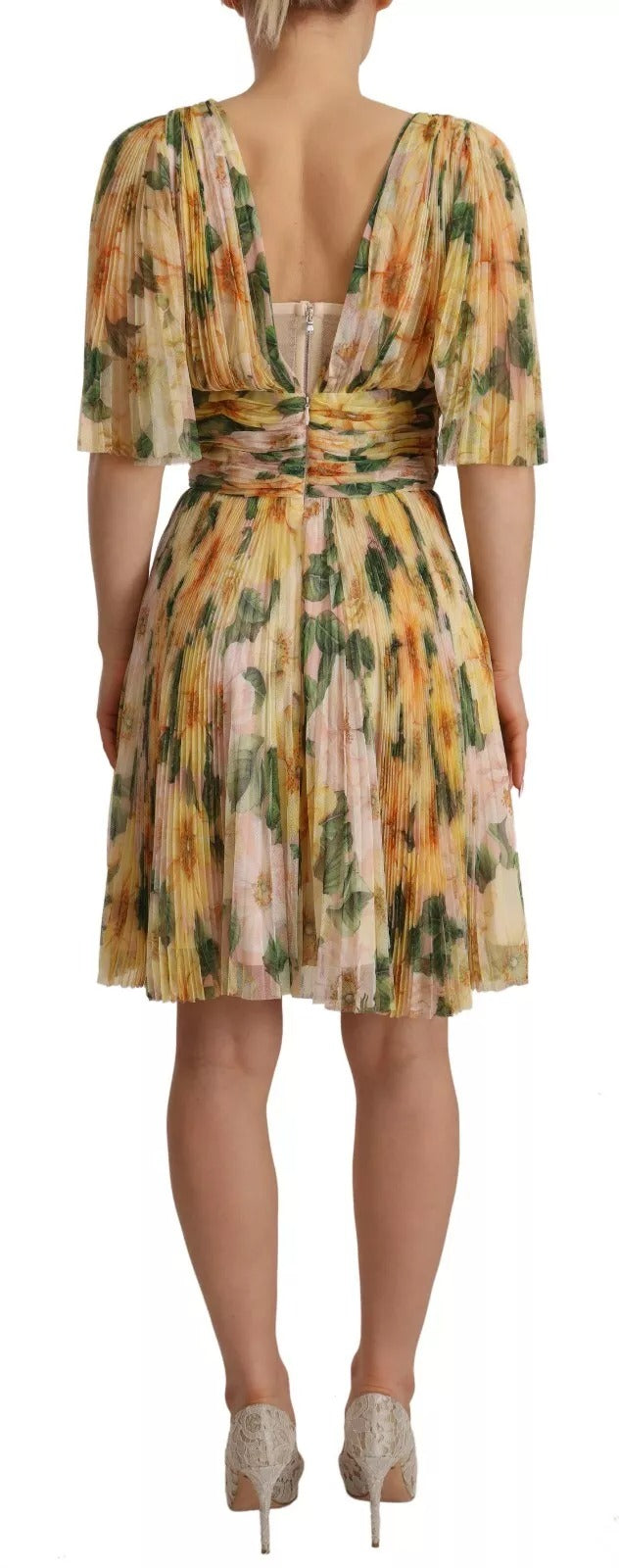 A woman's yellow floral print pleated maxi dress with a backless design and belt