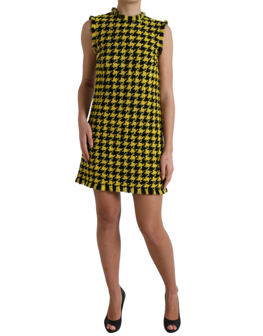 A sleeveless, yellow houndstooth mini dress with a V-neckline