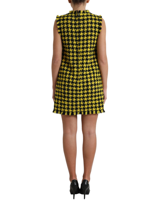 A sleeveless, yellow houndstooth mini dress with a fitted waist and aline skirt