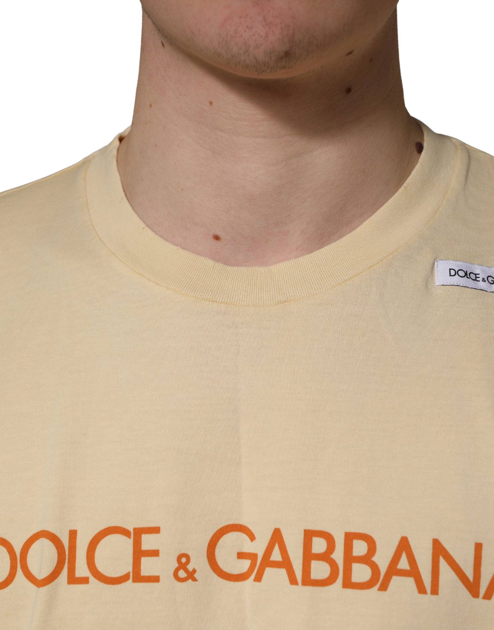 A yellow crew neck t-shirt with a logo print on the front